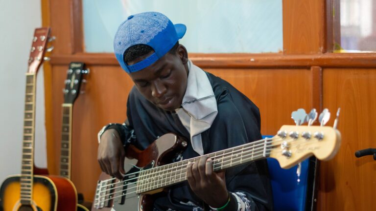 A man taking bass guitar lessons on a 5-string bass