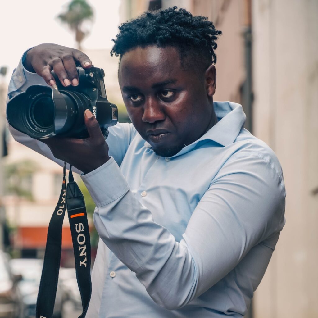 An image of a man holding a camera to take a photo
