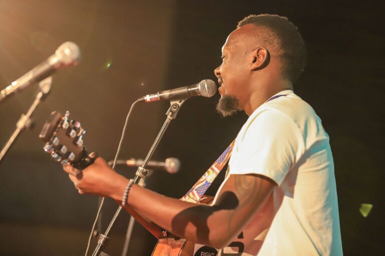 A man singing and playing a guitar